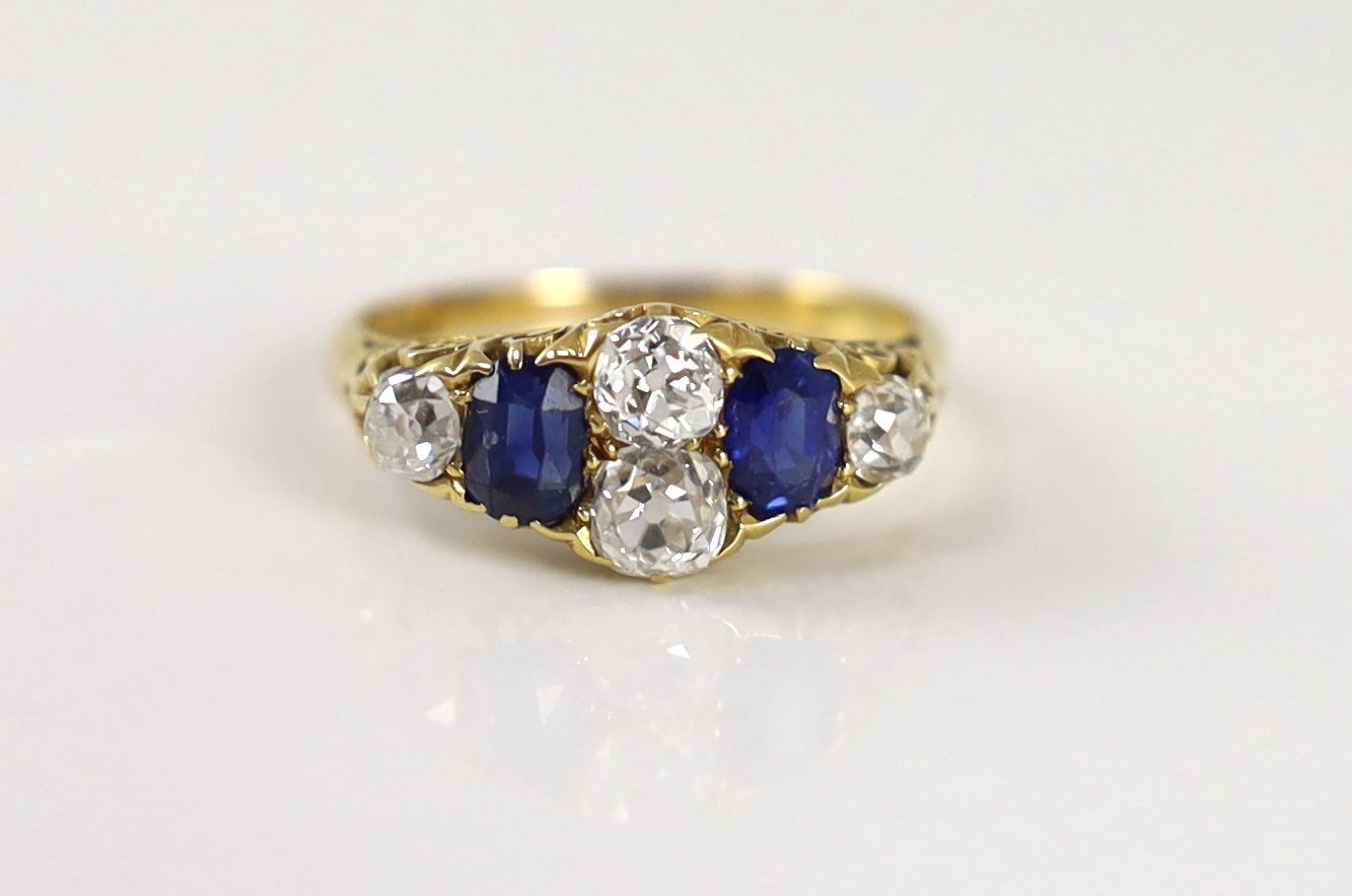 A Victorian style 18ct gold, four stone old round diamond and two stone sapphire set ring